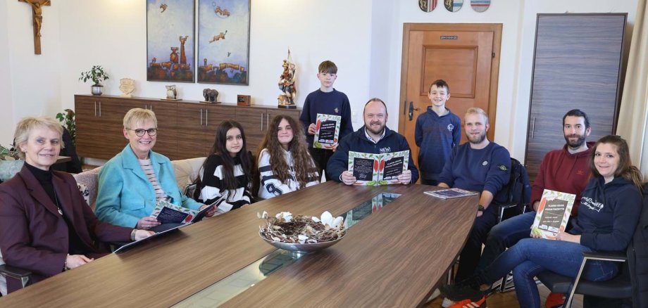 Schülerinnen und Schüler der 6. Klasse der Mittelschule Altenstadt stellen dem Landrat Andreas Meier ihr Kochbuch vor.