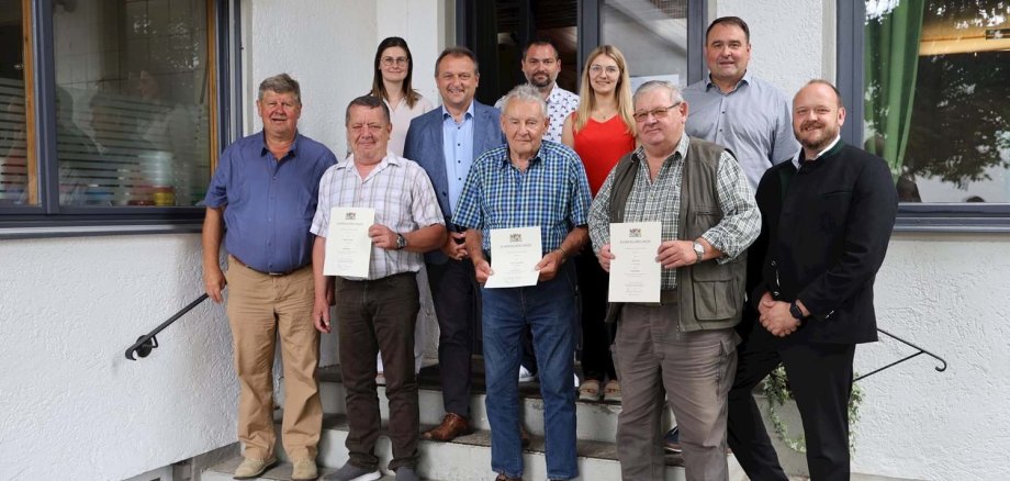 Vermessungsdirektor Joachim Gesierich (oben rechts) und Landrat Andreas Meier (rechts) ehrten Hubert Greiner und Karl List für 25 Jahre (1. Reihe 2./4. von links) sowie Ernst Frischholz (1. Reihe Mitte) für 50 Jahre Dienst als Feldgeschworener.