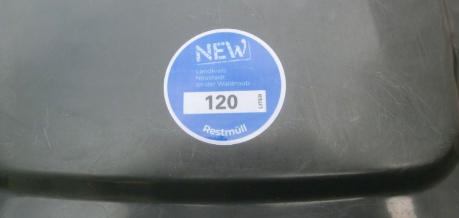 Nahaufnahme des Deckels einer Restmülltonne mit einer blauen Abfallmarke des Landkreises Neustadt an der Waldnaab. Die Marke zeigt die Größe der Tonne (120 Liter) und ist für das Jahr 2019 gültig.