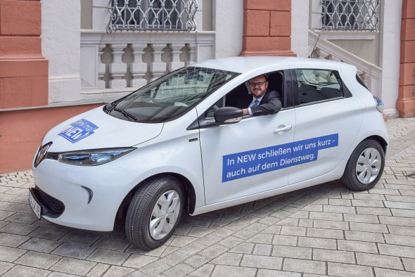 Landrat Andreas Meier am Steuer eines kleinen weißen Elektroautos. Elektromobilität im Landkreis Neustadt an der Waldnaab: Alternative Antriebe bringen uns dem Klimaziel näher
