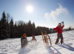Kinder spielen mit ihrem Schlitten im Schnee.
