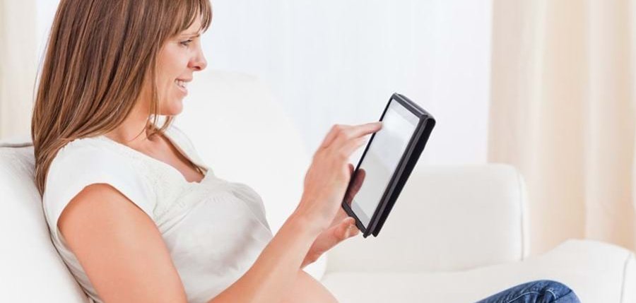 Schwangere Frau mit einem Tablet