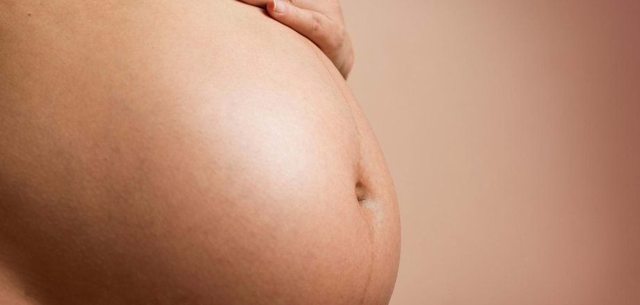 Babybauch und Hand einer Person